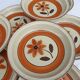 Set 11 plates 1970 Revernay Sarreguemines orange and brown on sandstone background