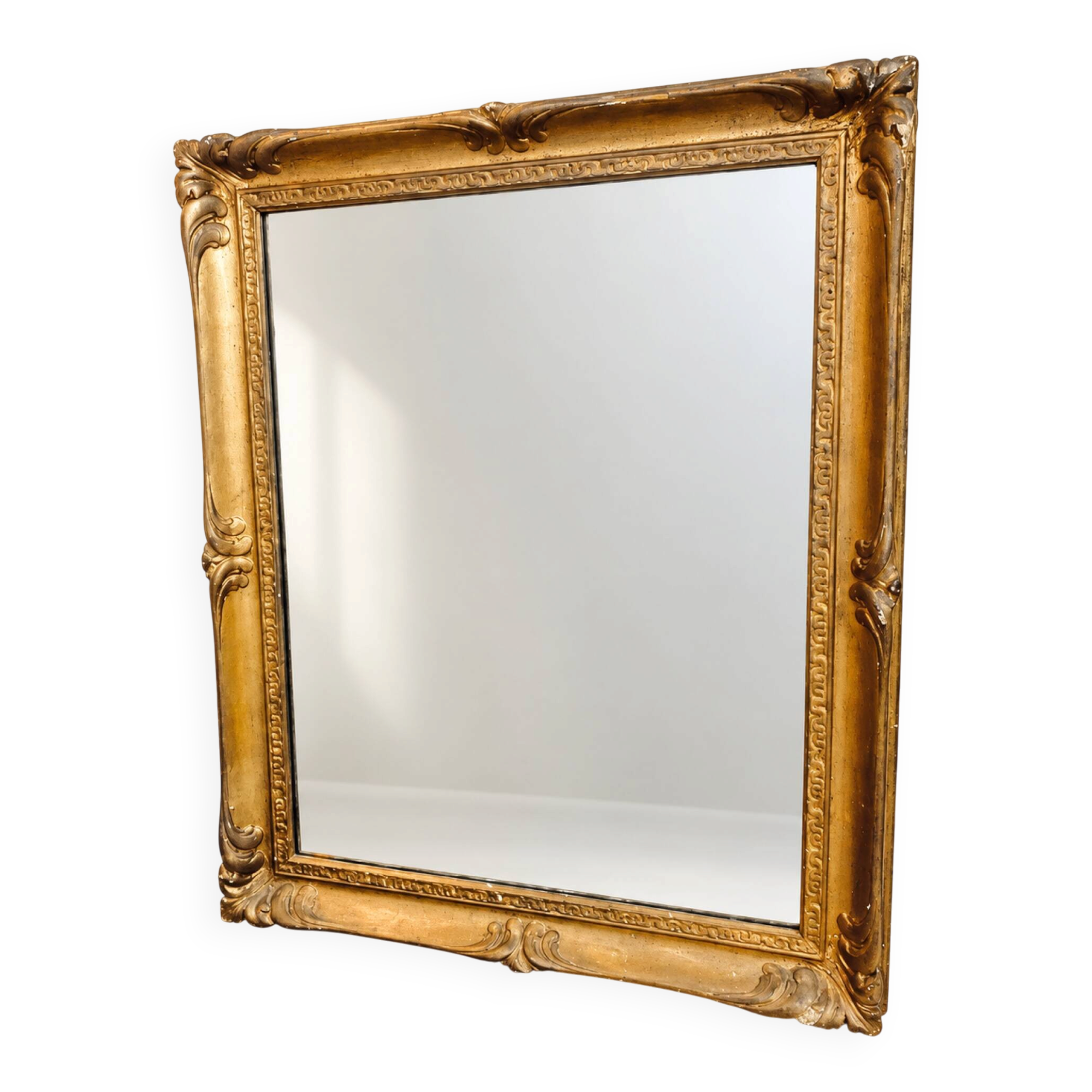 Antique mirror with a gilded frame and foliage decoration.