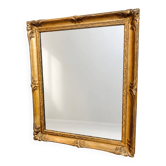 Antique mirror with a gilded frame and foliage decoration.
