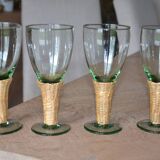 Four stemmed glasses surrounded by rattan.
