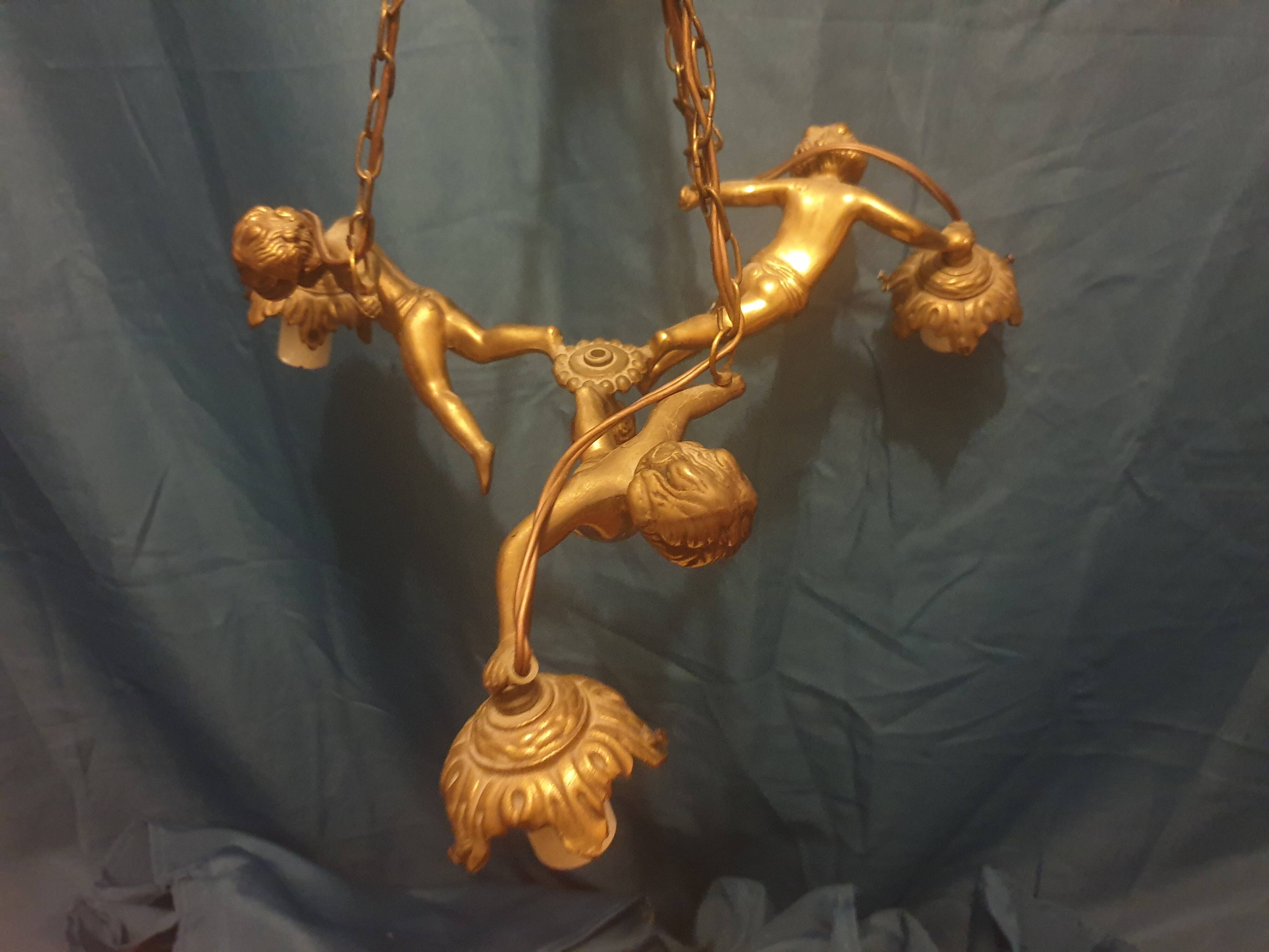 Antique chandelier decorated with cherubs and putti angels taken from the attic