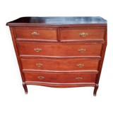 Style set: bevelled mirror and curved wooden chest of drawers.