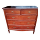 Style set: bevelled mirror and curved wooden chest of drawers.