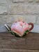 Ceramic teapot in the shape of a rose with a butterfly and raised petals.