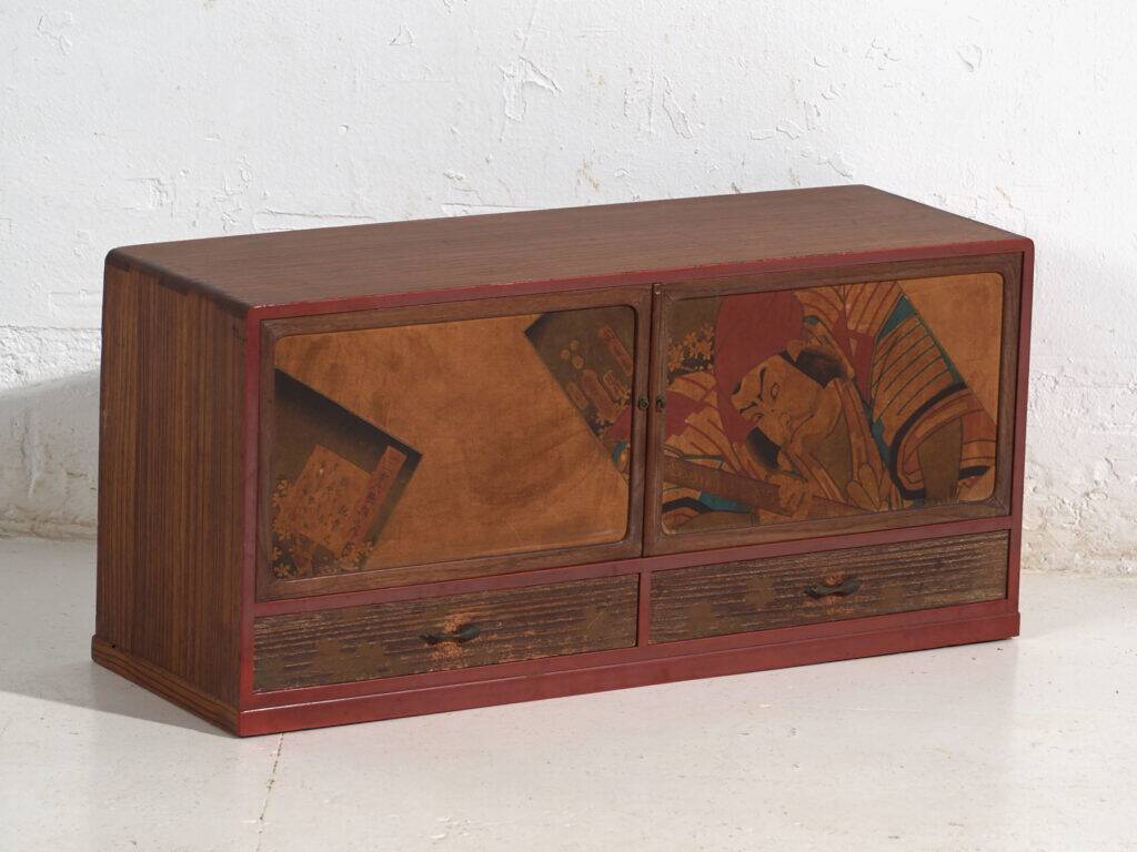 Small Japanese cabinet with sliding doors, Kabuki decoration, made of paulownia wood, early Showa period, circa 1926–1970.