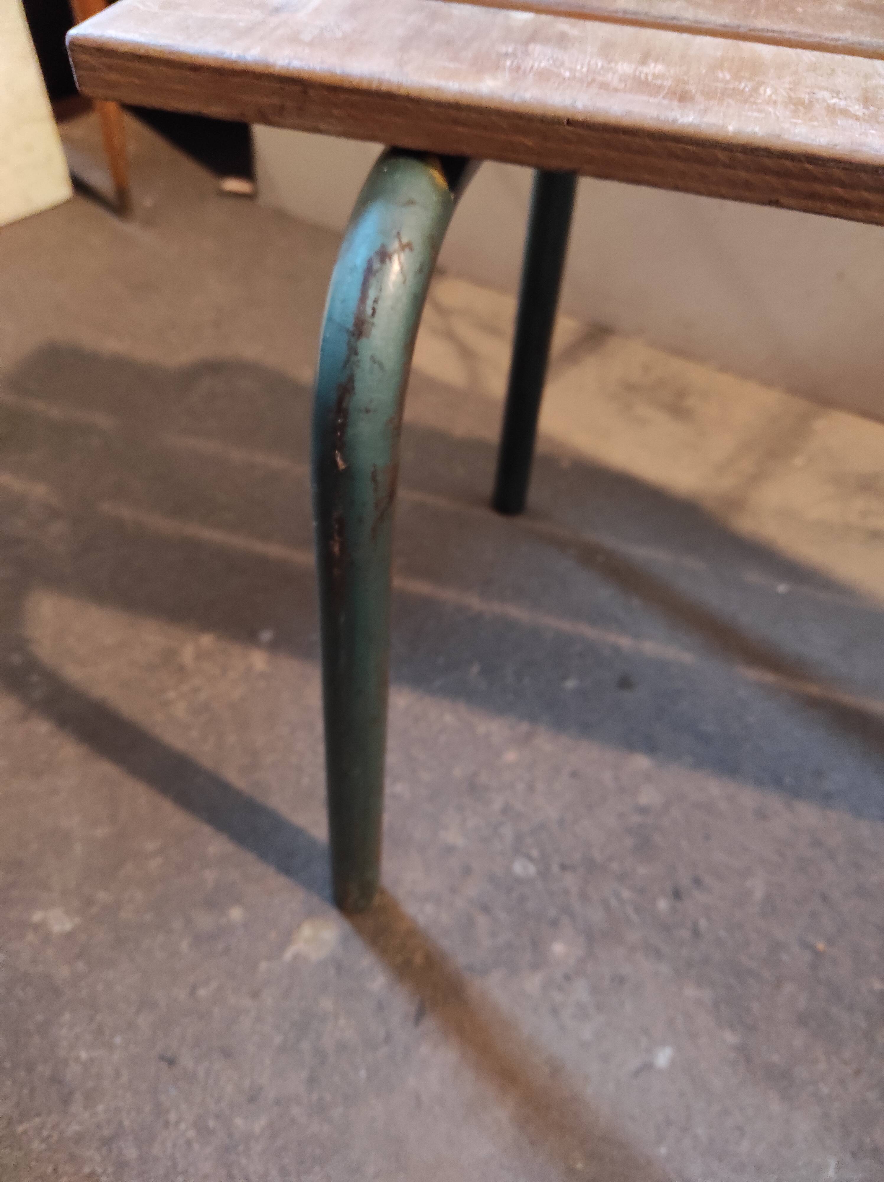 Former vintage wooden school bench and metal tubes