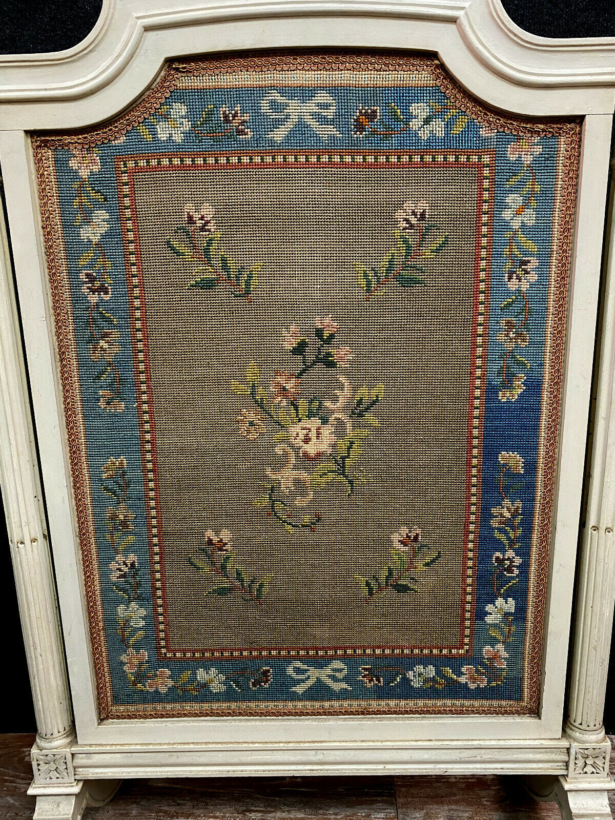 Front of Louis XVI fireplace in laqué wood and fabric has floral decorations