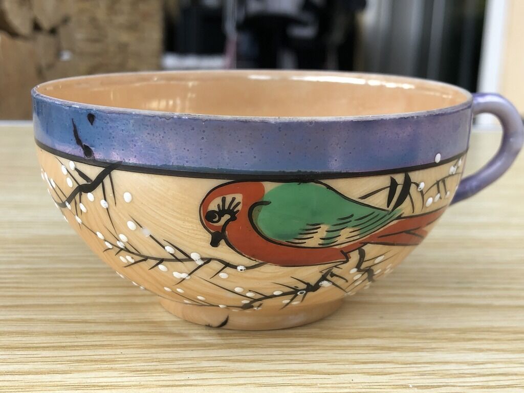 Bird-decorated cup and cup with golden reflection