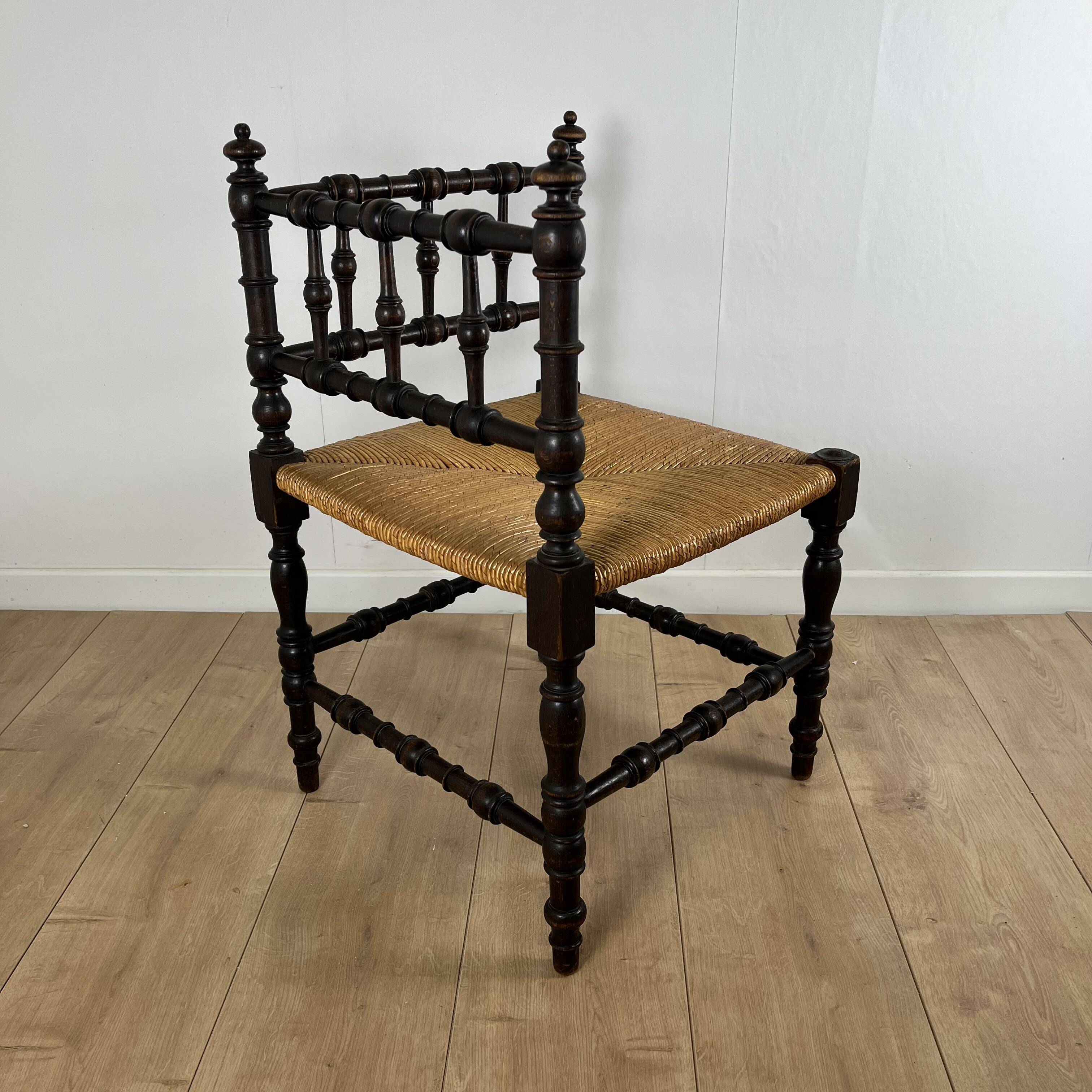 Corner chair in carved wood and straw, late 19th century.