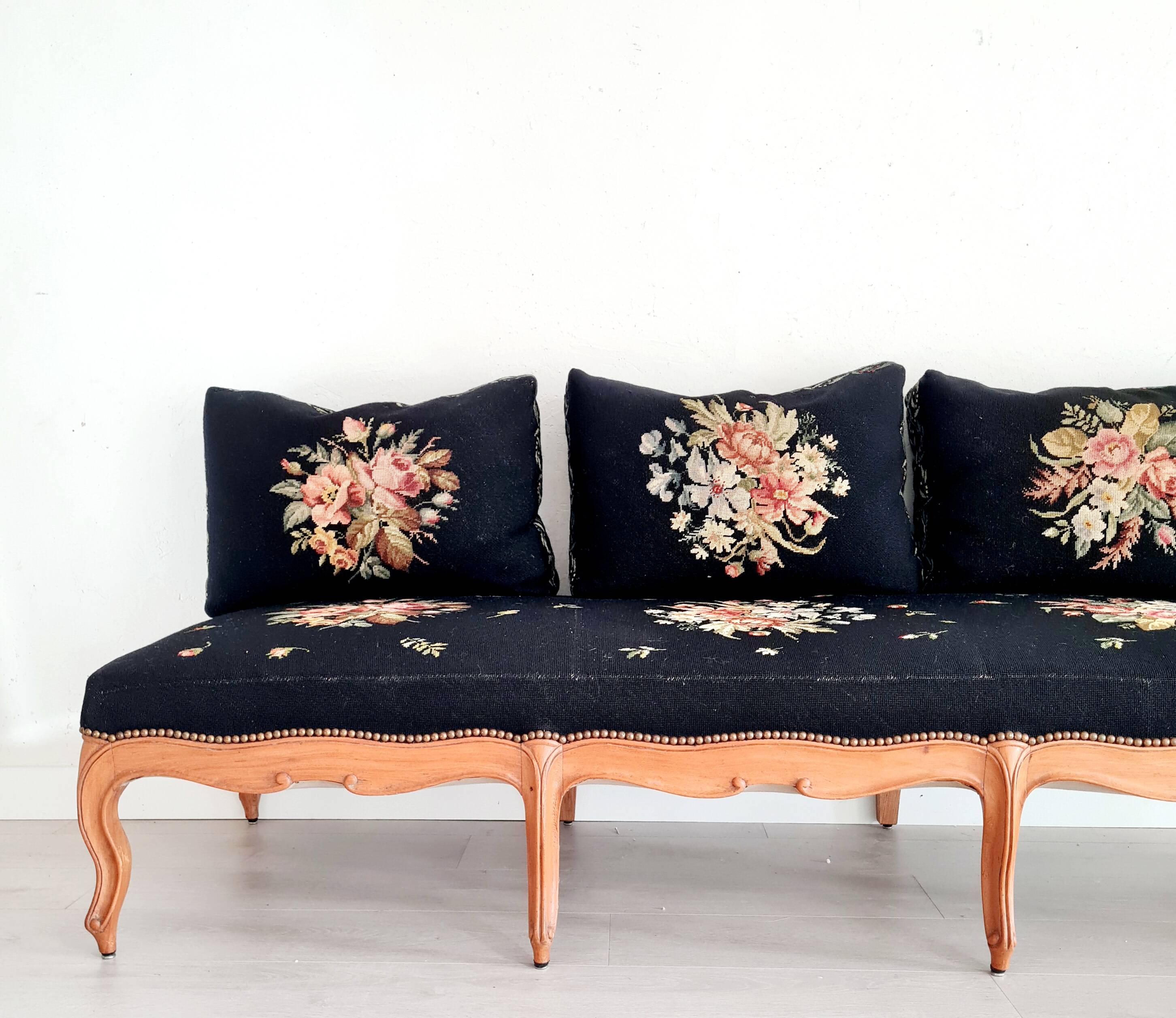 Old bench upholstered in black canvas flowers
