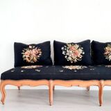 Old bench upholstered in black canvas flowers