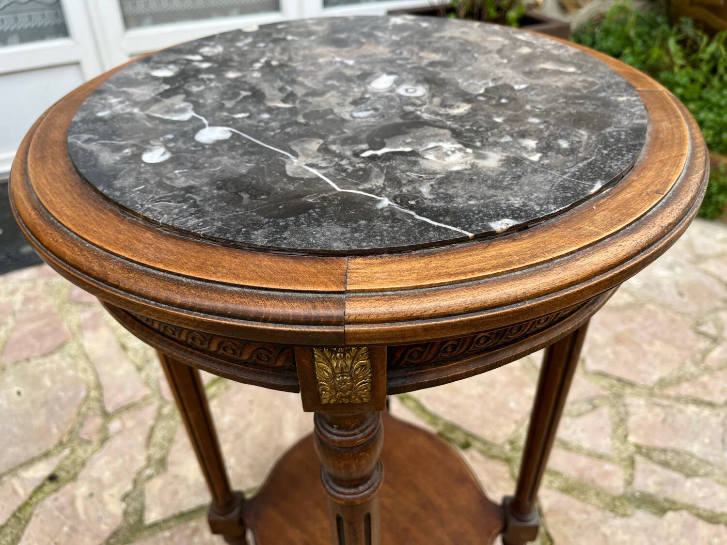 Old wooden pedestal table with marble top
