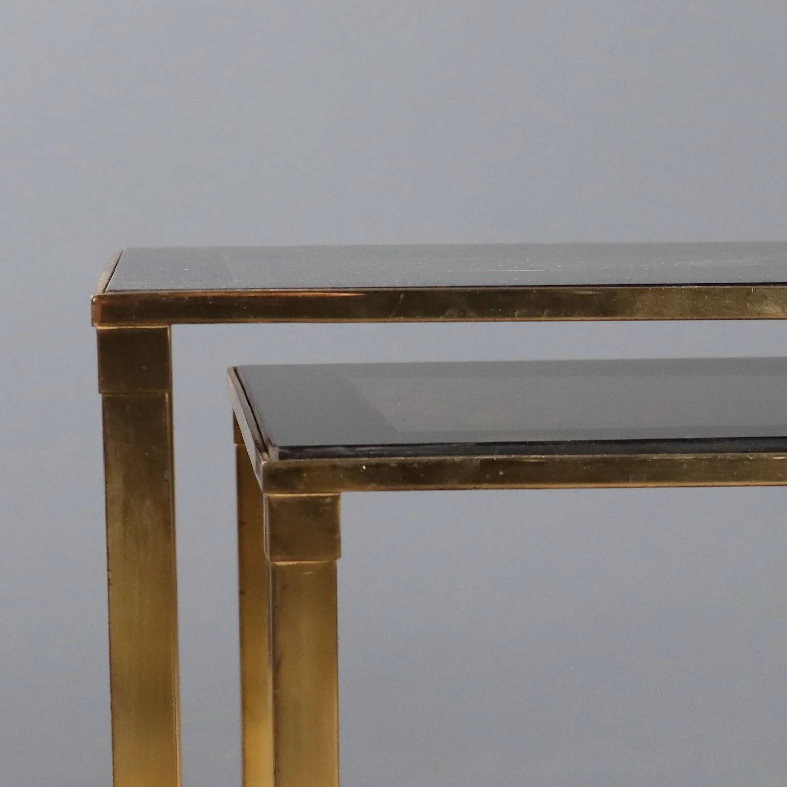 Nested tables in brass and smoked glass.