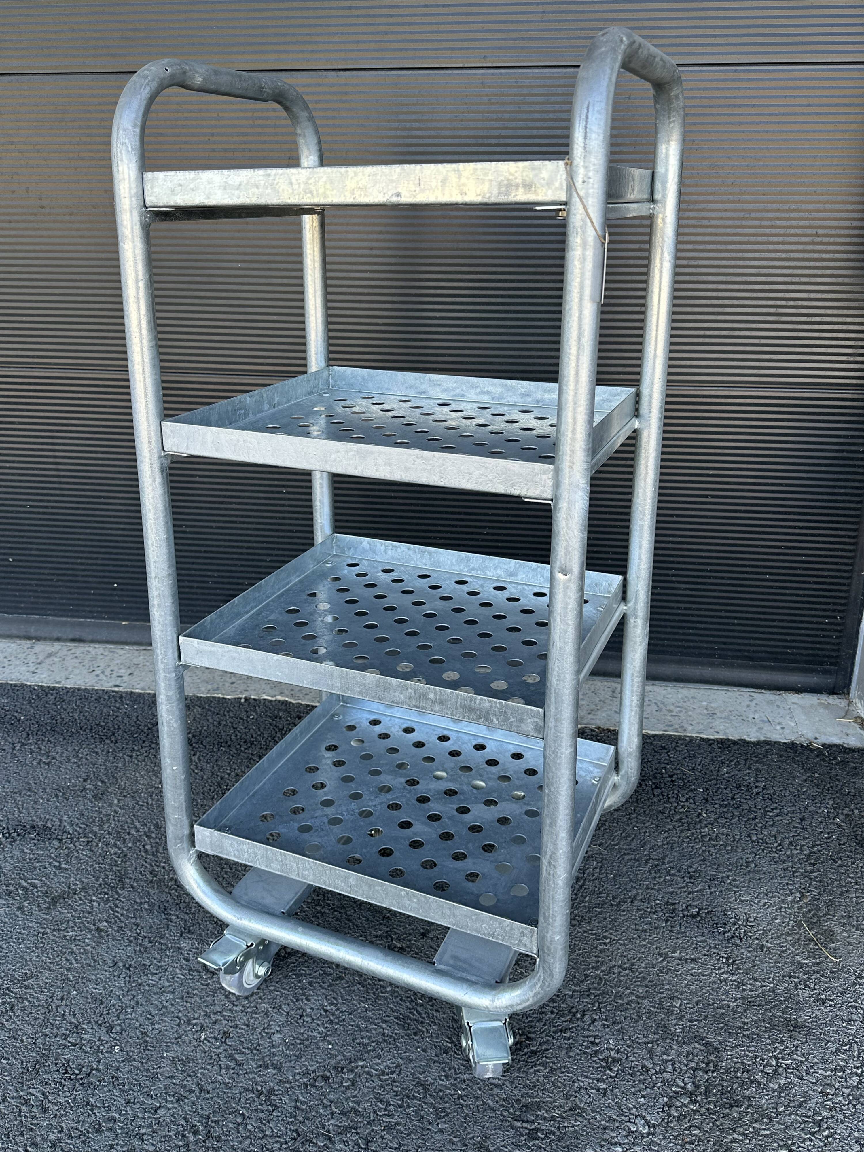 Four-wheeled dessert trolley with 4 perforated metal shelves.