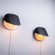 Matte black wall lamps with perforated shades and brass details