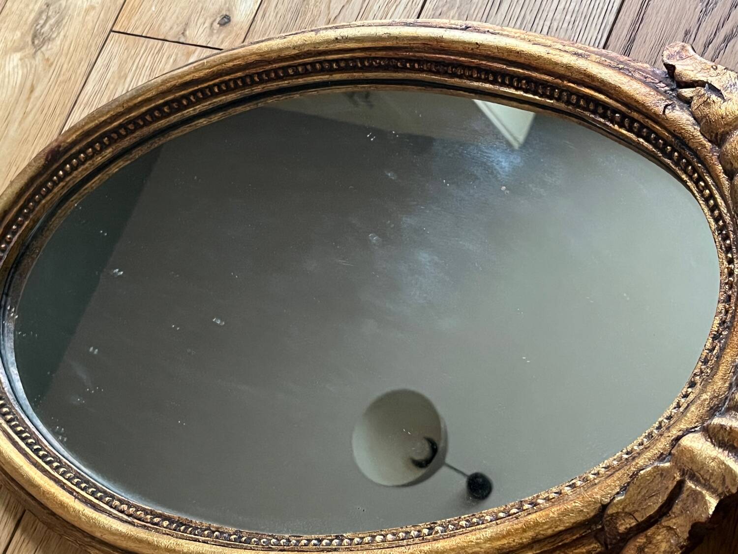 Old oval gilded stucco mirror