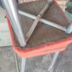 Pair of aluminum bar stools with orange and black seats