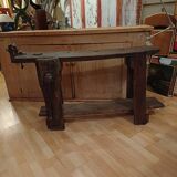 Small, very old, brutalist workbench equipped with a period workshop lamp