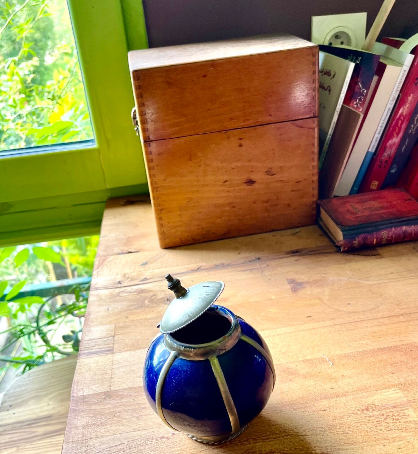 Small blue ceramic pot with metal frame and lid.