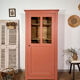 Antique glass-fronted terracotta cupboard