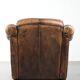 Fauteuil en peau de mouton magnifiquement conçu et confortable, avec un look intemporel et une finition de passepoil assortie.