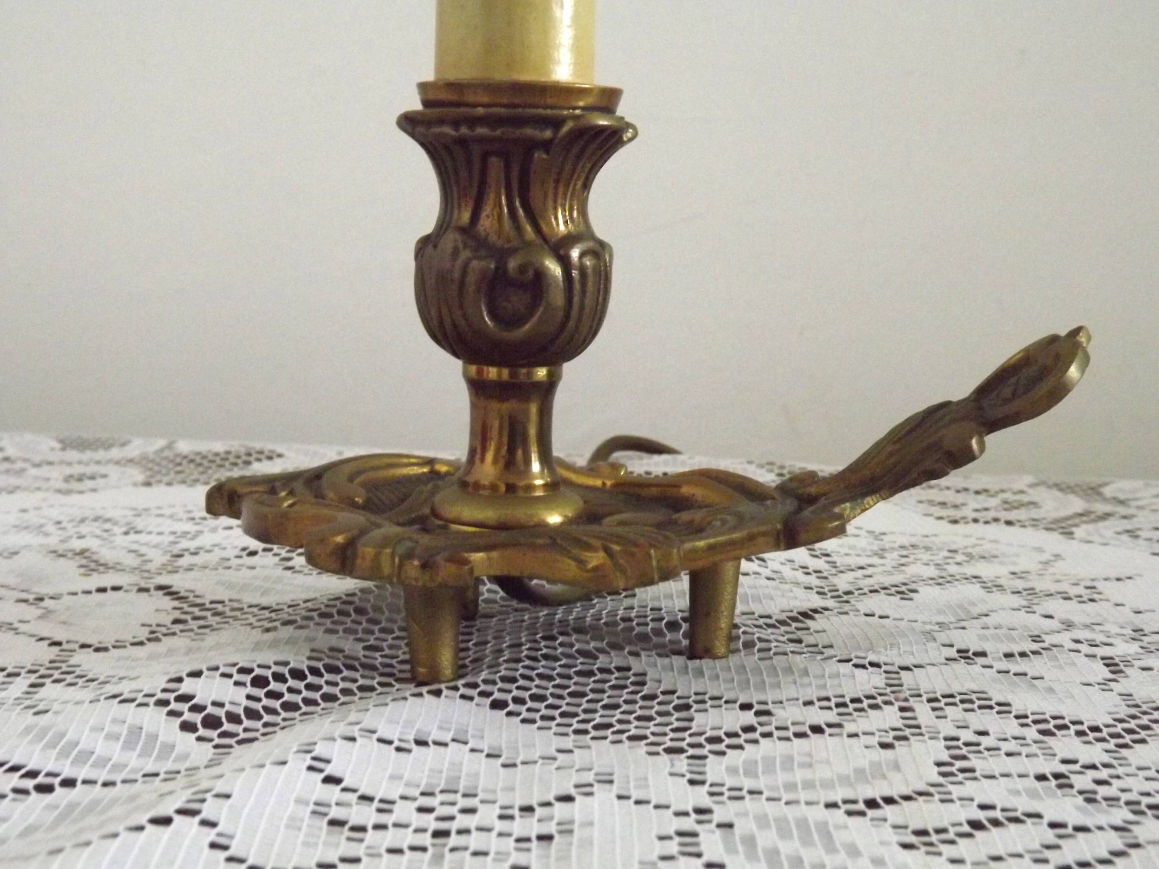 Vintage French bronze Wee Willie Winkie style lamp with red card shade.