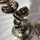 Two silver-plated metal candlesticks decorated with cherubs, 20th century