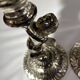 Two silver-plated metal candlesticks decorated with cherubs, 20th century