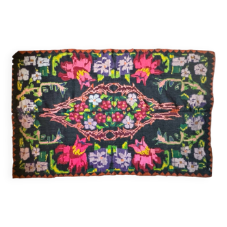 Bohemian floral design, handwoven wool rug, black background with colorful flowers