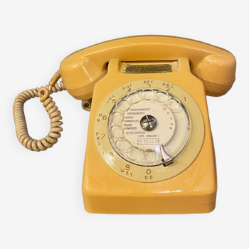 Old dial telephone from the 80s temat quimper bakelite yellow and beige