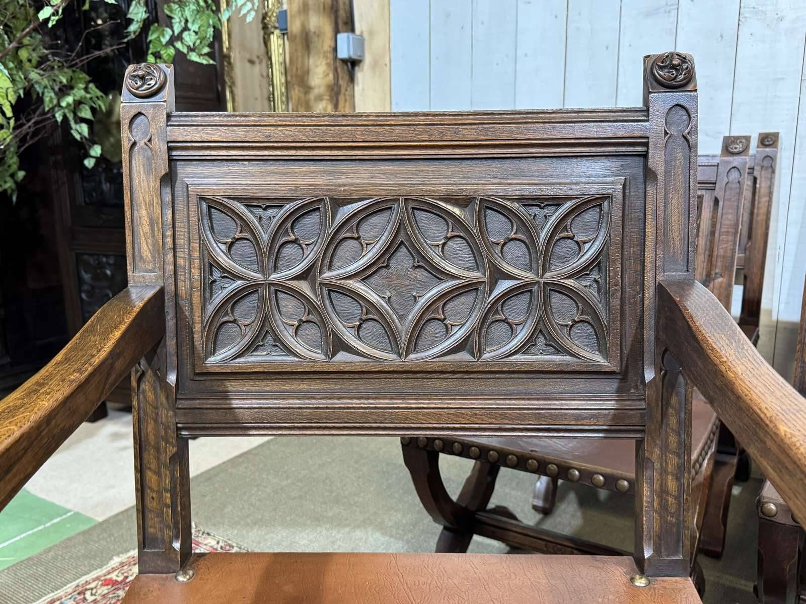 Suite de 6 chaises et 2 fauteuils en chêne et cuir à décor gothique