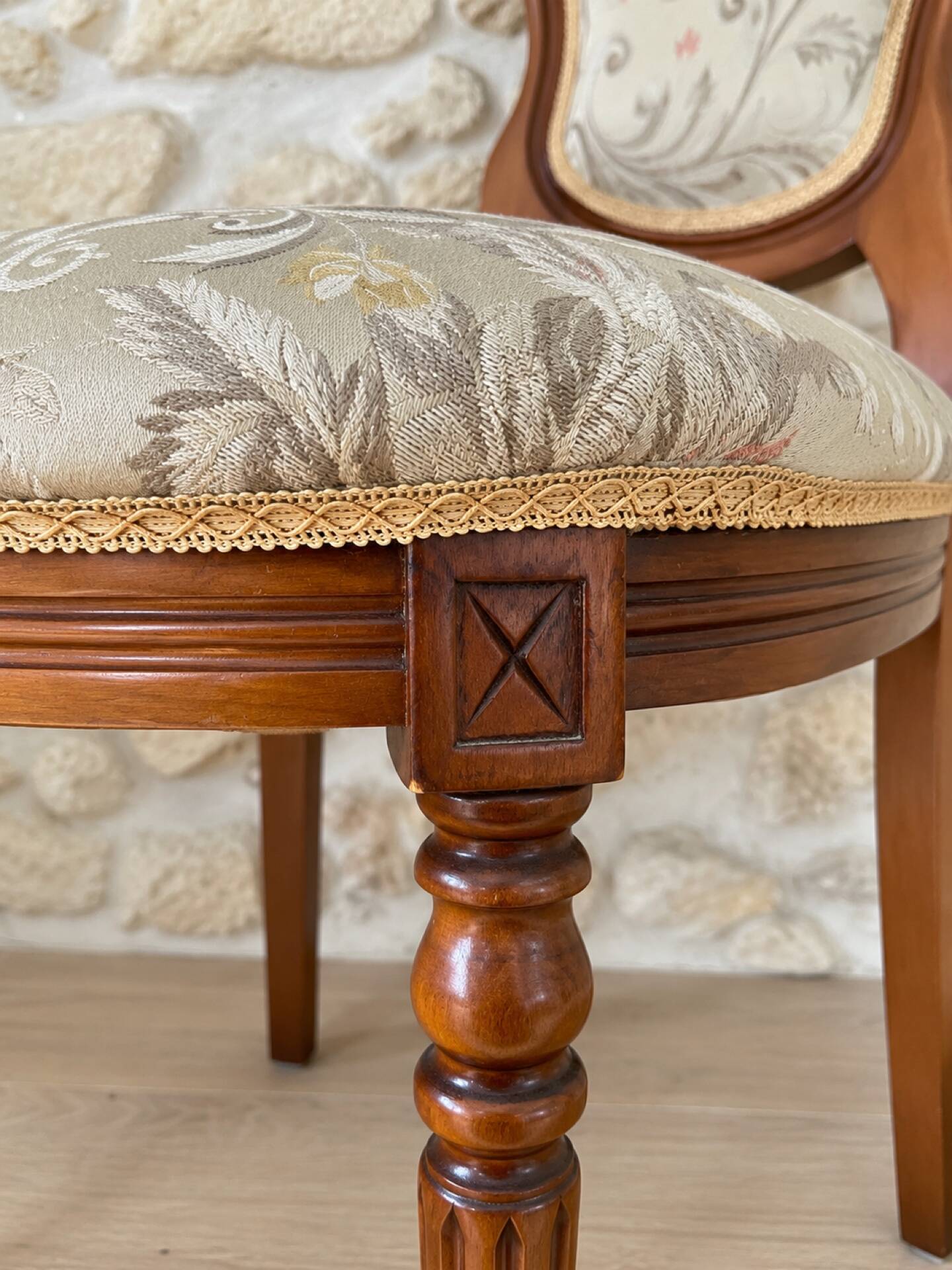 Antique Louis XVI style chair in wood and floral fabric.