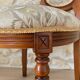 Antique Louis XVI style chair in wood and floral fabric.