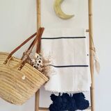 Handwoven throw with black stripes and pom-poms