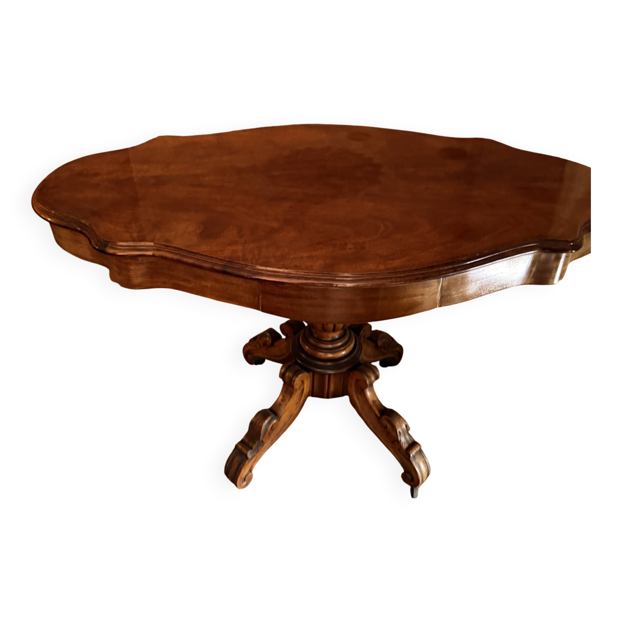 Antique mahogany table with a scalloped top and a sculpted central leg.