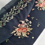 Old bench upholstered in black canvas flowers
