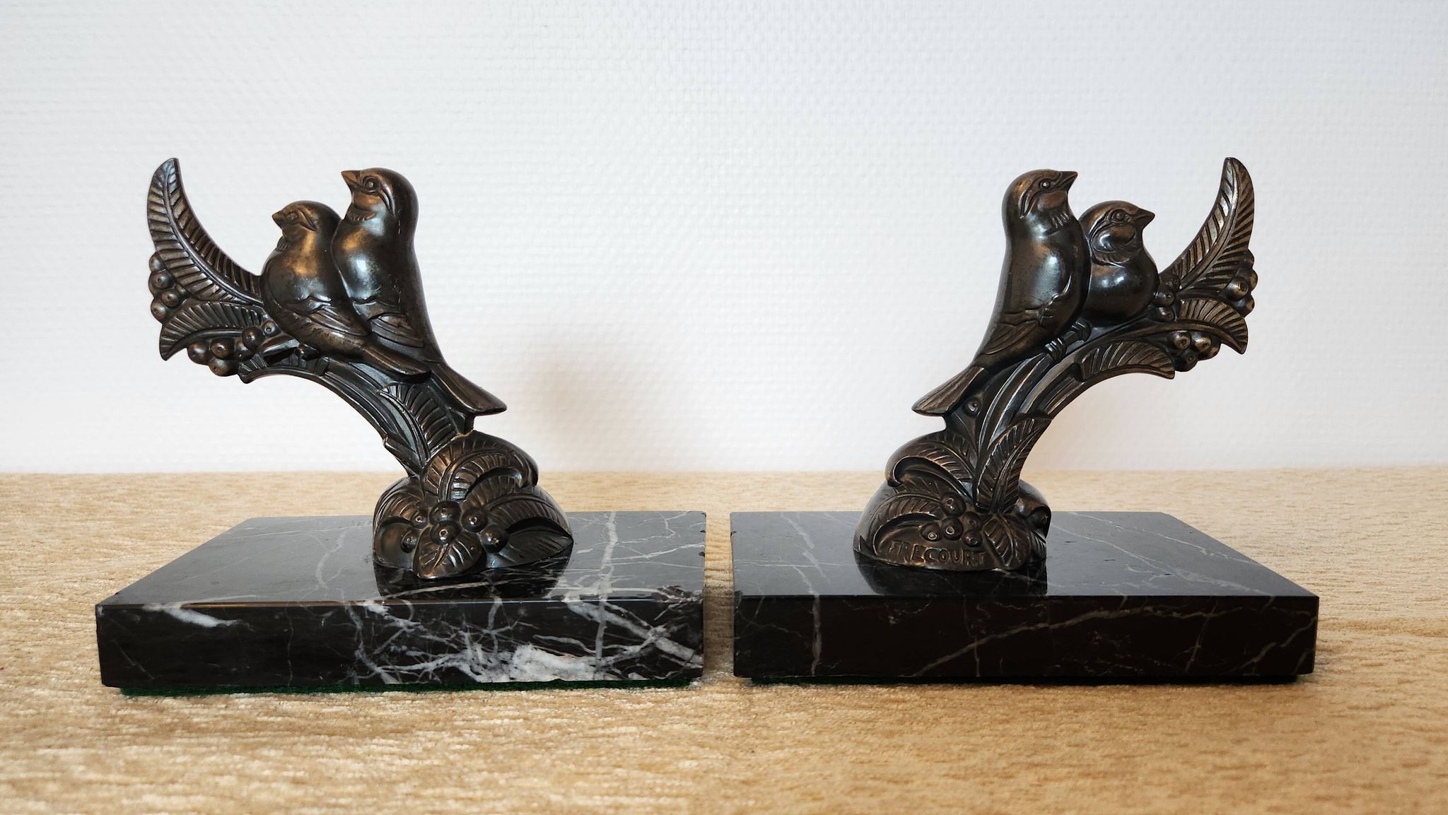 Pair of Art Deco bookends signed Frécourt, patinated metal & black marble