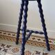 Vintage tripod stool made of turned wood, painted blue.