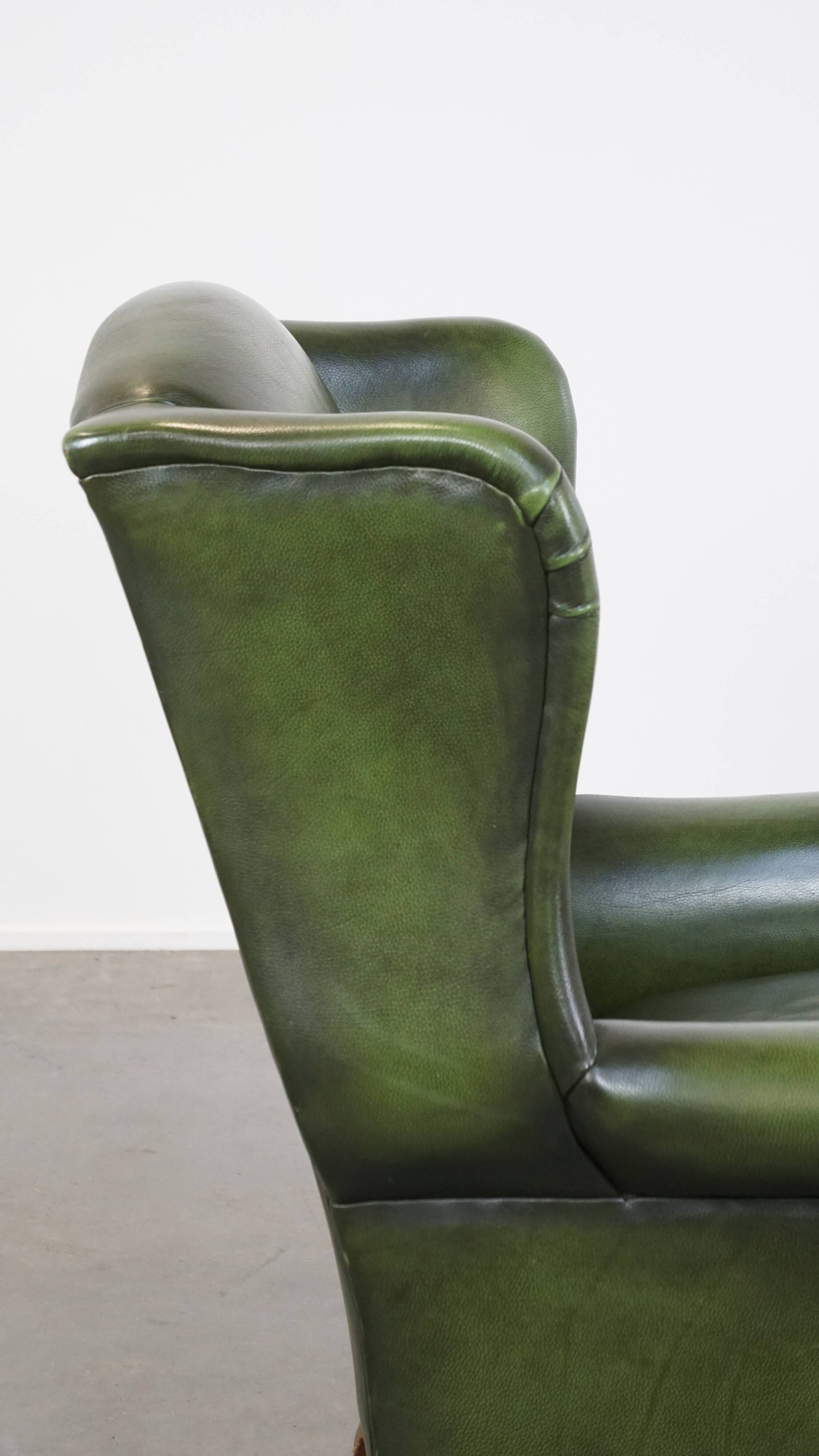 Fauteuil à oreilles Chesterfield anglais en cuir de vache vert avec une assise confortable