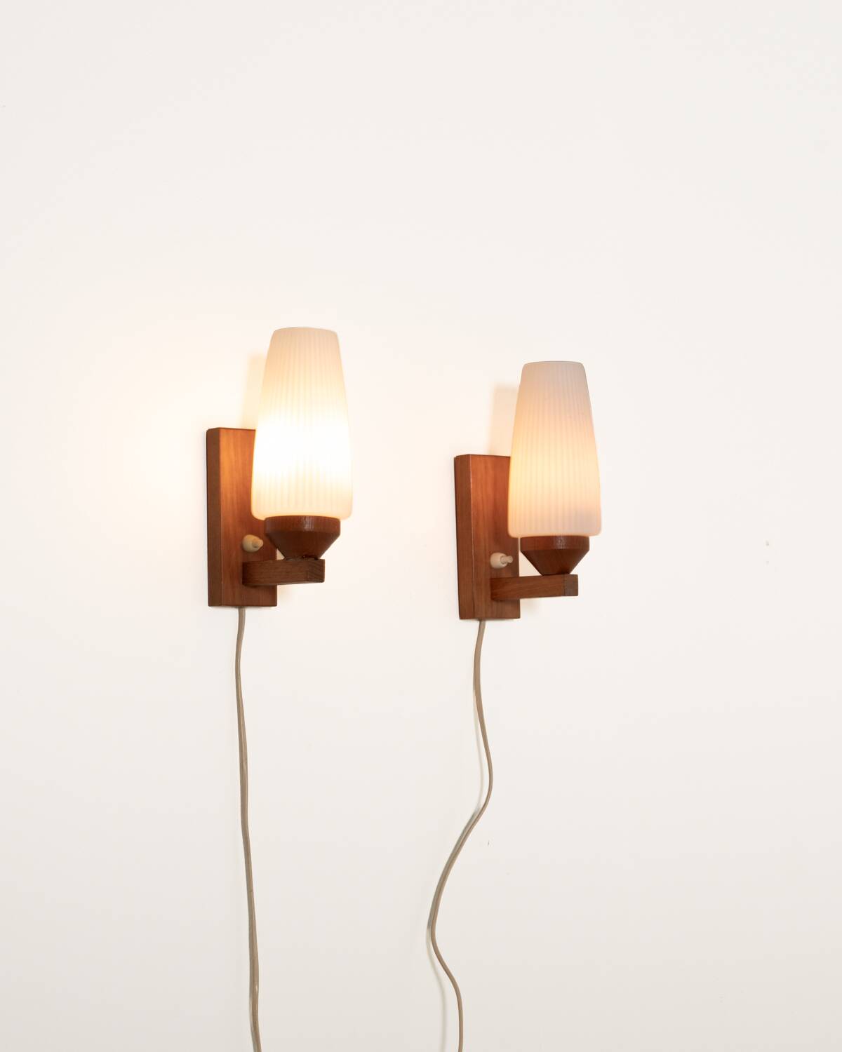 Pair of teak and opaline glass wall lamps, 1950s/1960s