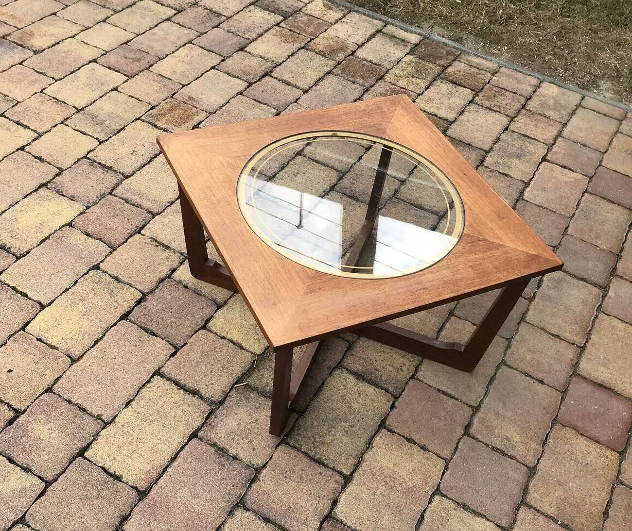 Round glass coffee table with a gold border and brown teak structure, Astro 1960s style.