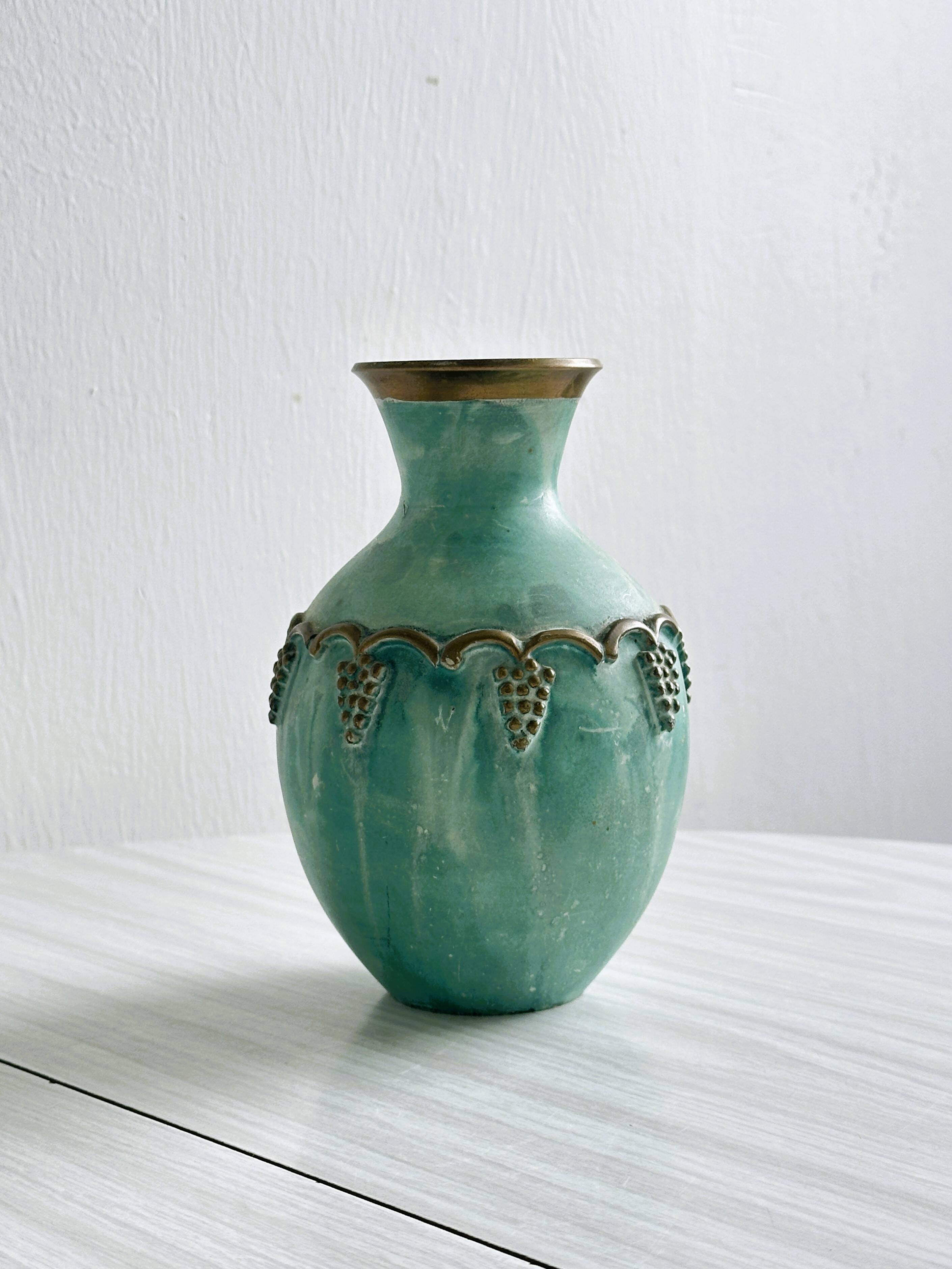 Brass vase decorated with bunches of grapes.