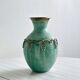 Brass vase decorated with bunches of grapes.