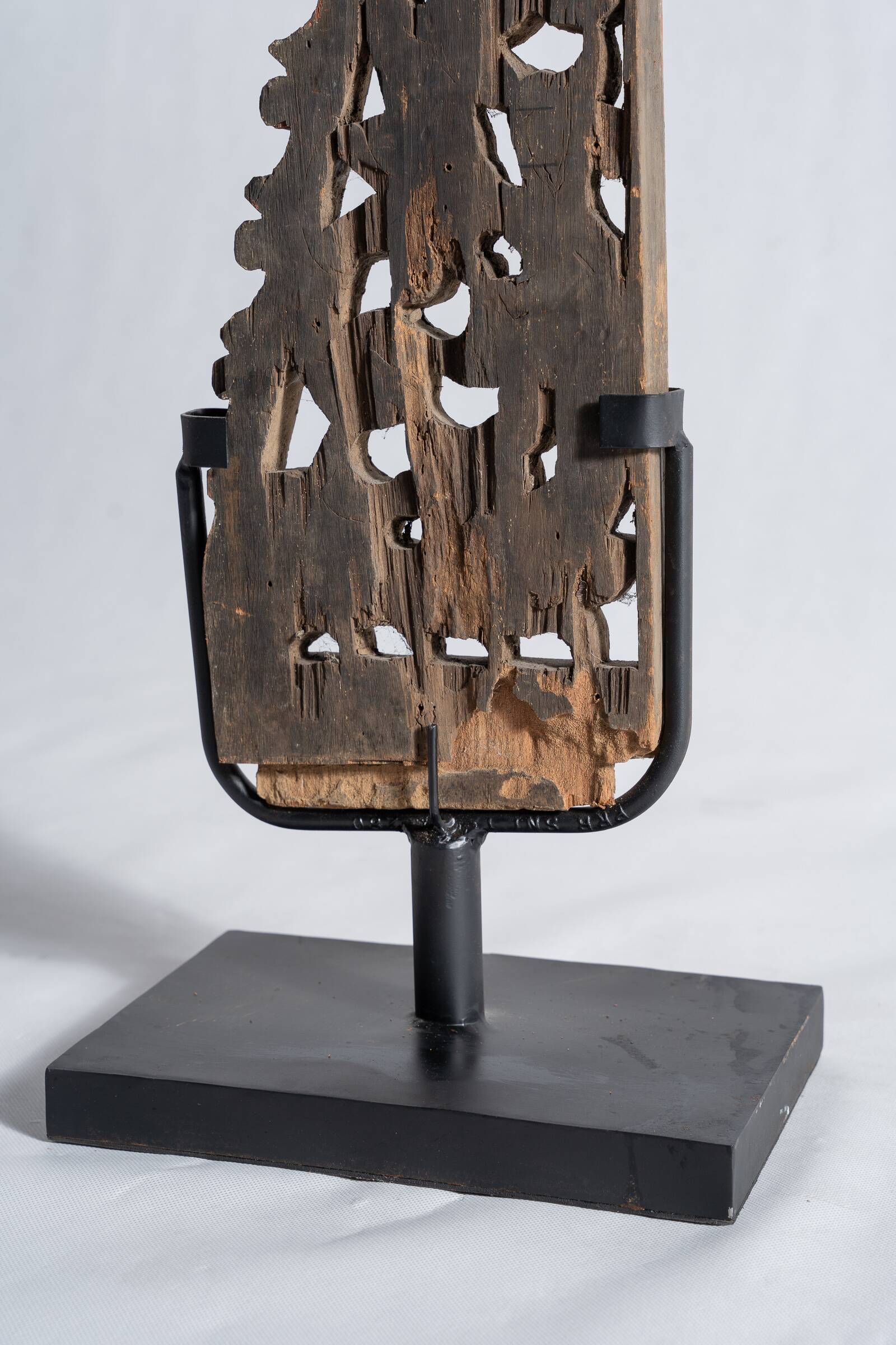 Indonesian construction element in carved wood with intertwined plant motifs mounted on a base (fri