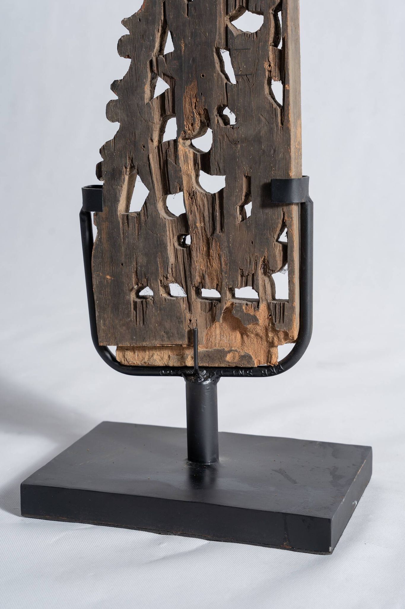 Indonesian construction element in carved wood with intertwined plant motifs mounted on a base (fri