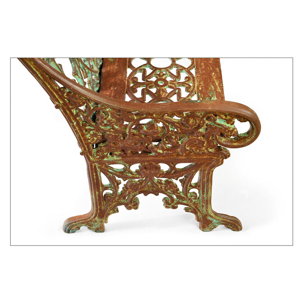 Sculpted cast iron bench with green patina