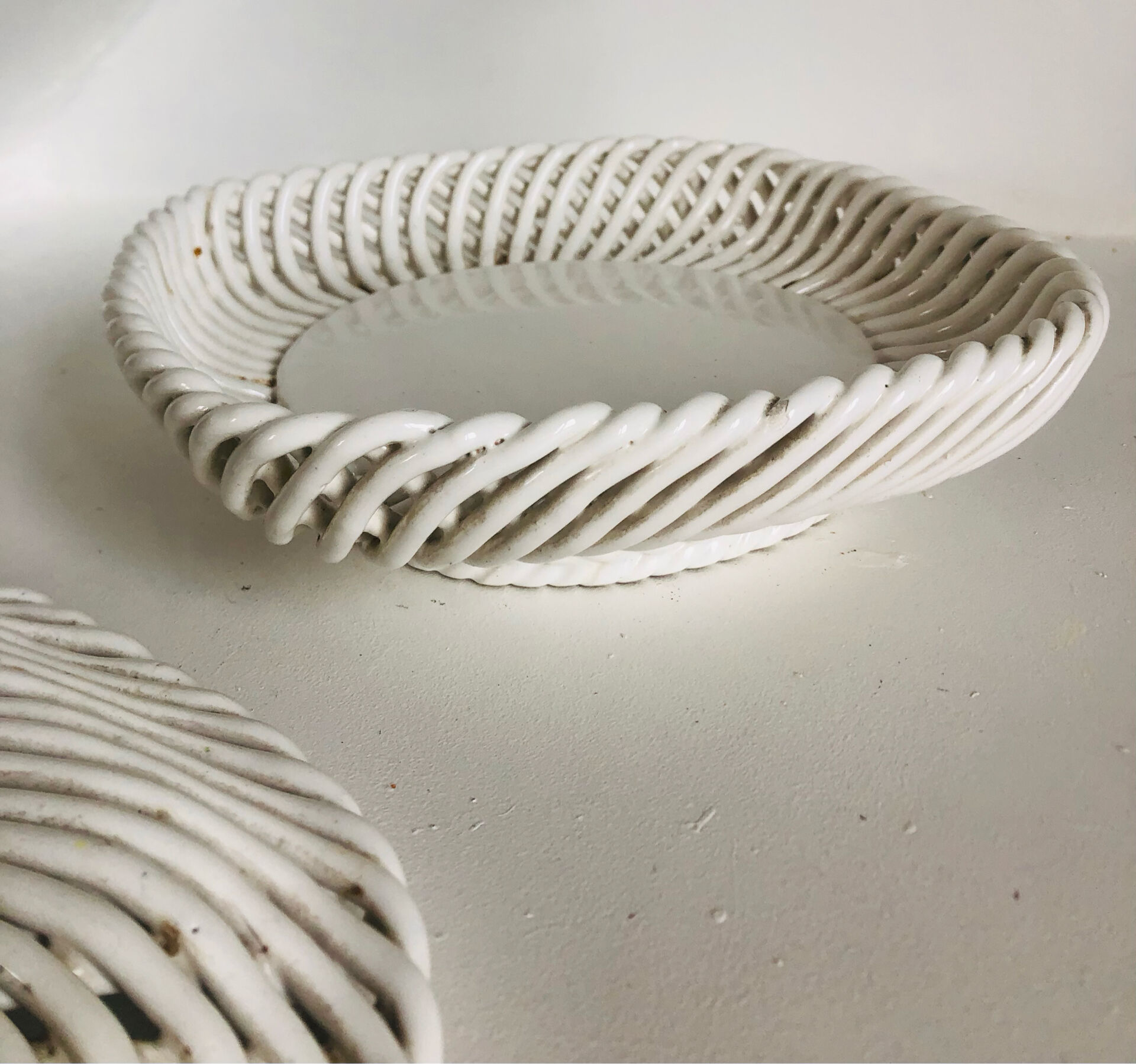 Covered basket in white woven ceramic and fruit slip.