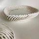 Covered basket in white woven ceramic and fruit slip.