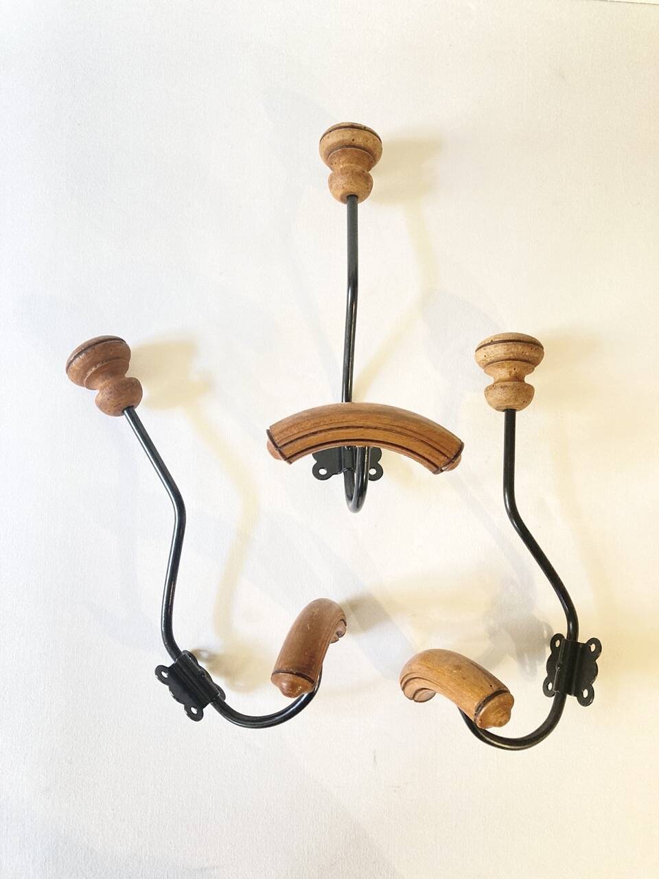 Trio of antique wooden and metal coat hooks