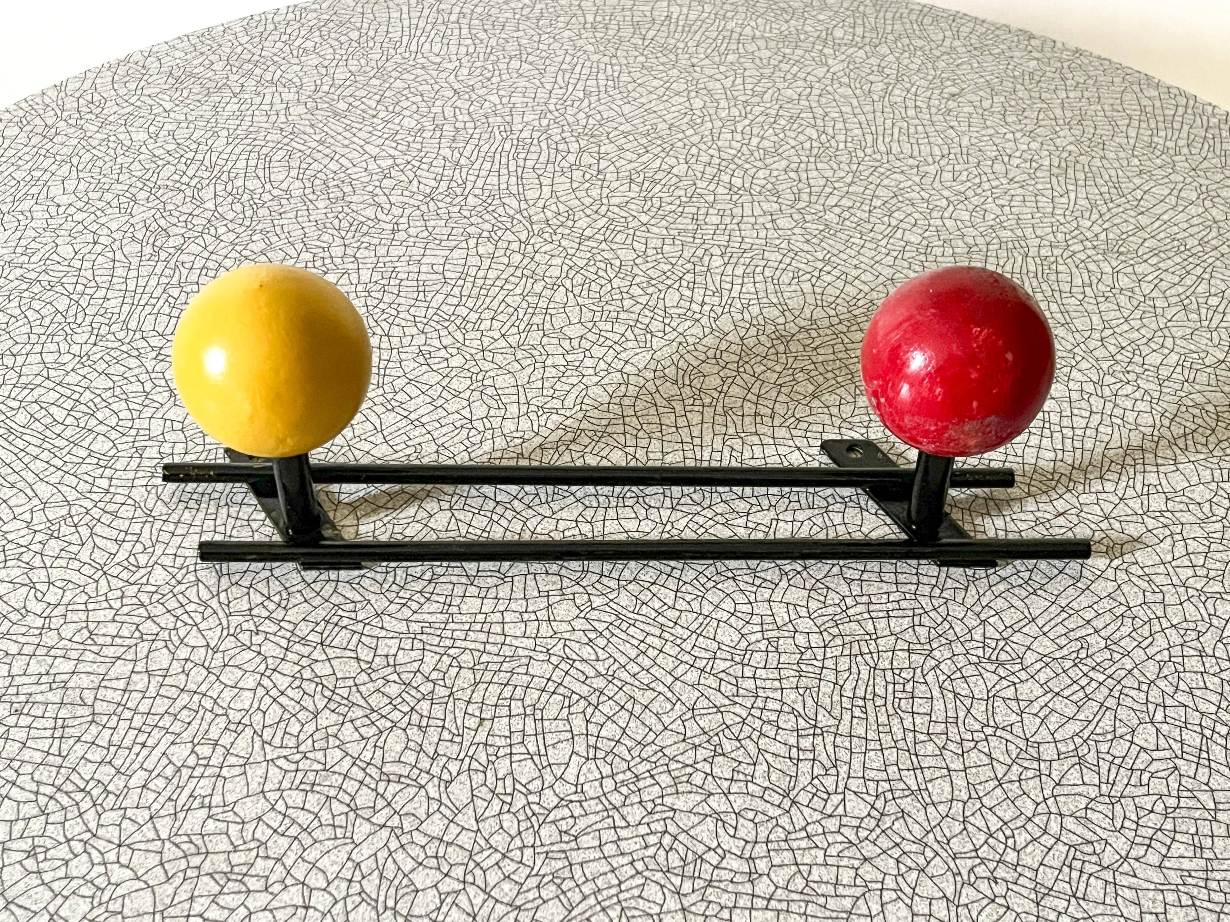 Vintage wall coat rack, metal and wood in yellow and red.